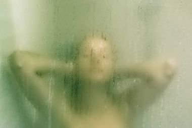 Güzel kadın duş ile cam arkasında bırakır. Yeşil parıltı