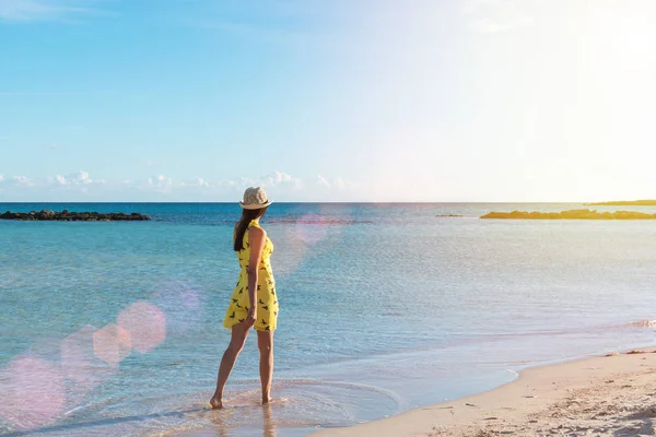 Een eenzaam meisje loopt langs de kust eiland en heeft reflectie op natte zand. — Stockfoto