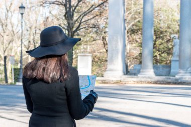 Kadın turist şehir sokakta haritaya arıyor.