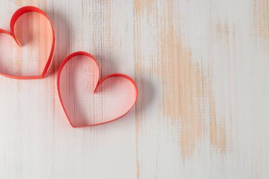 İki kalp şerit ahşap arka plan üzerinde yapılmış. Sevgililer günü.