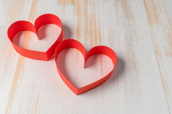 Dwa serca wykonana ze wstążki na podłoże drewniane. Walentynki. — Zdjęcie stockowe