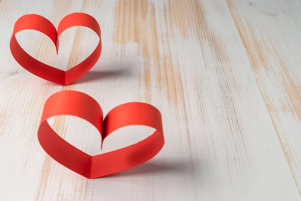 Twee harten gemaakt van lint op houten achtergrond. Valentijnsdag. — Stockfoto