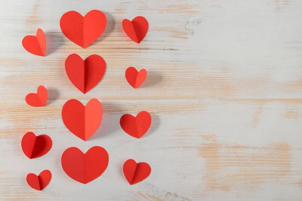 Rood papier hartjes op houten achtergrond. Valentijnsdag. — Stockfoto