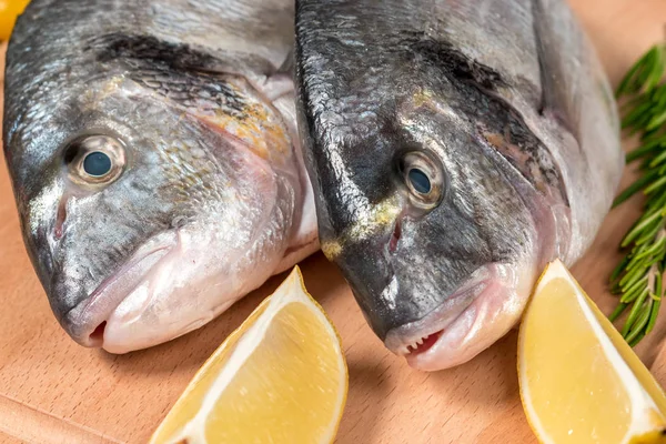 Fresh uncooked dorado or sea bream fish with lemon and herbs — Stock Photo, Image