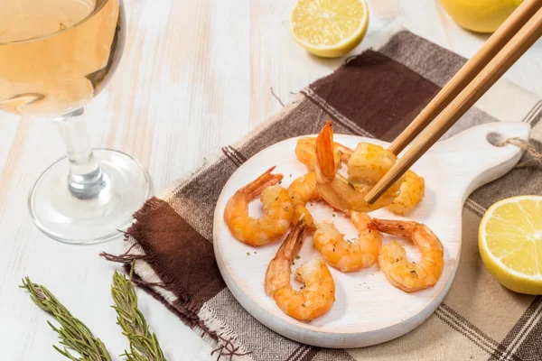Fried shrimps with chopsticks on a white wooden board — Stock Photo, Image