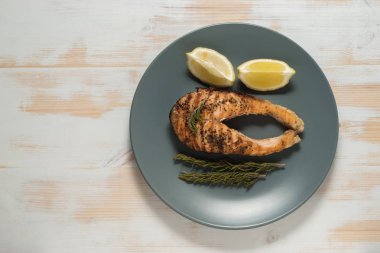 Somon fileto. Ot ve plaka üzerinde limon ile ızgara somon. 