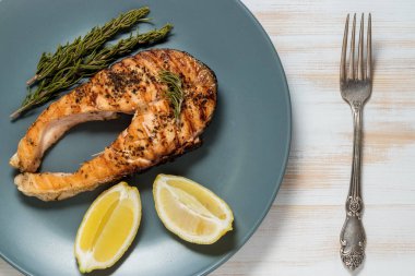 Somon fileto. Ot ve plaka üzerinde limon ile ızgara somon. 