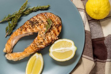 Somon fileto. Ot ve plaka üzerinde limon ile ızgara somon. 