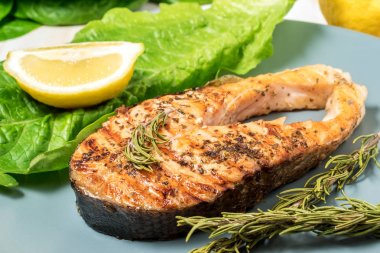 Somon fileto. Ot ve plaka üzerinde limon ile ızgara somon. 