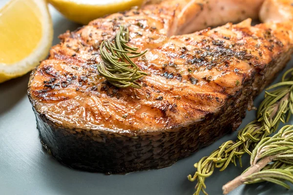 Filete de salmón. Salmón a la parrilla con hierbas y limón en el plato . — Foto de Stock