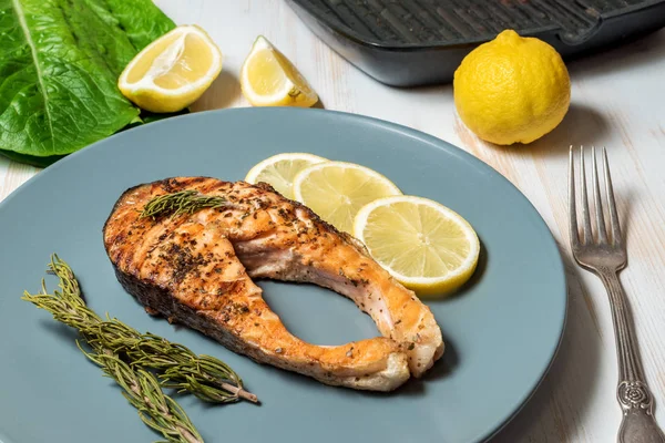 Salmon fillet. Grilled salmon with herb and lemon on plate.