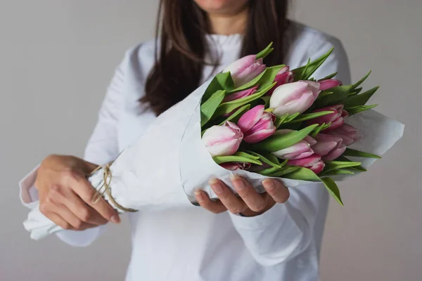 Spring bouquet of pink tulips in woman's hands — Stock Photo, Image