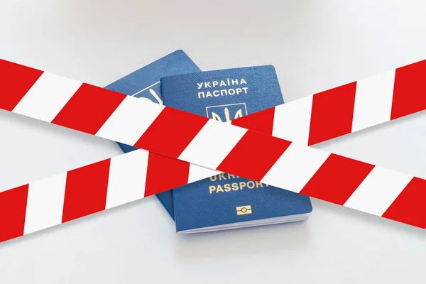 Biało -czerwone taśmy ostrzegawcze przez dwa paszporty Ukraina. — Zdjęcie stockowe