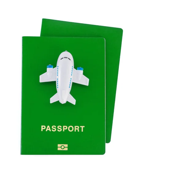 Mały samolot zabawka na szczycie zielonych paszportów na białym tle — Zdjęcie stockowe