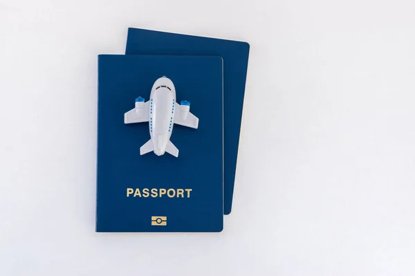 Zabawka mały samolot na górze niebieski paszporty na białym tle. — Zdjęcie stockowe