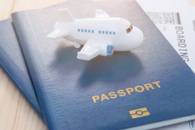 Mavi pasaporta biniş kartı ile tepesinde küçük oyuncak uçak