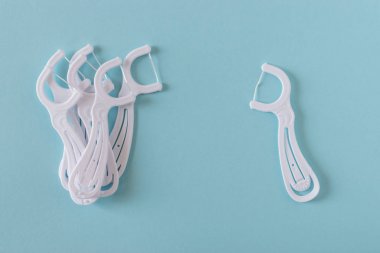 Parlak mavi zemin üzerine beyaz diş flossers.