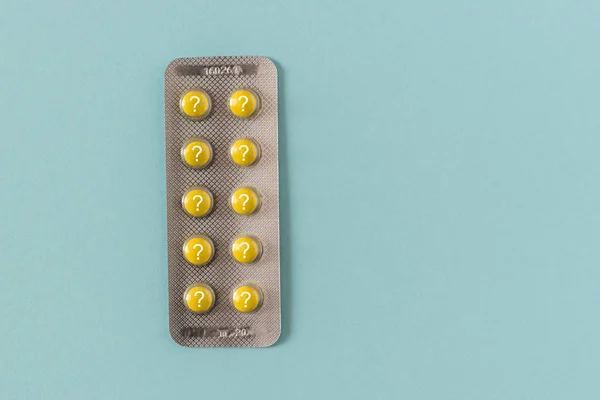 Κίτρινο χάπια με ερωτηματικό σε μπλε φόντο. — Φωτογραφία Αρχείου