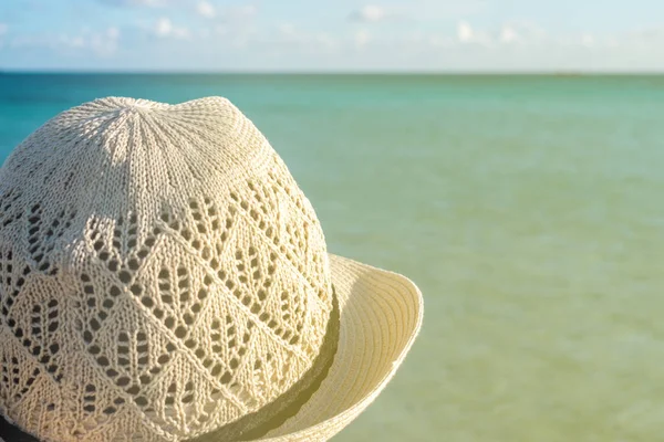 Vrouw in stro hoed op het strand — Stockfoto