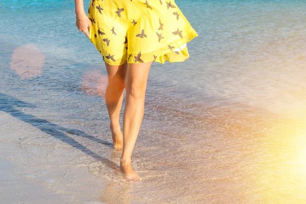 Una ragazza sola cammina lungo la costa dell'isola e si riflette sulla sabbia bagnata — Foto Stock