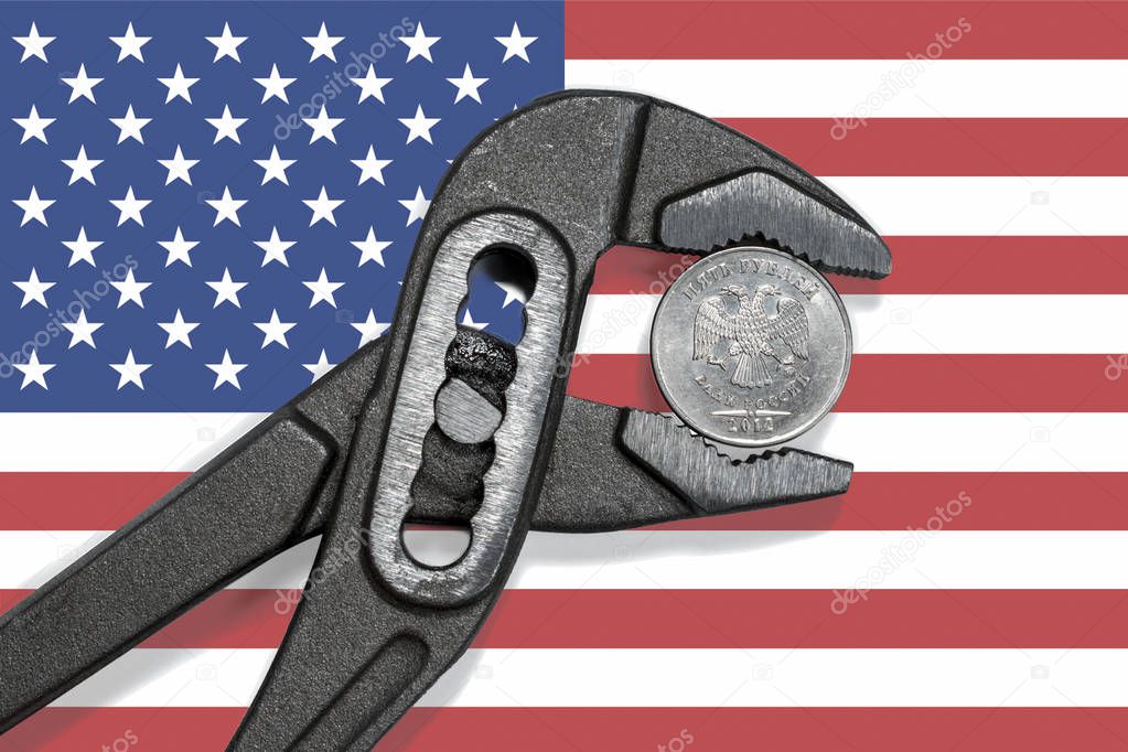 The coin in vise on the background of flag of  USA as a symbol of economic sanctions against of Russia