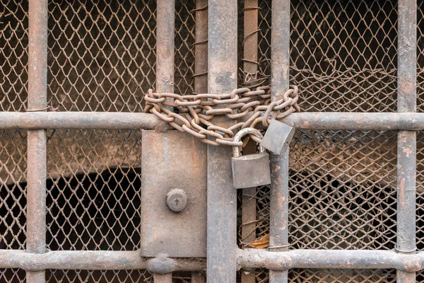 Closed bars with old chain and lock