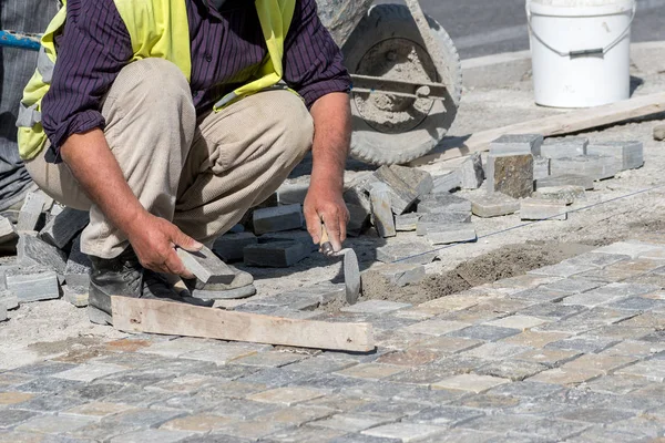 Construction worker installing stone blocks on the street. — Stock Photo, Image