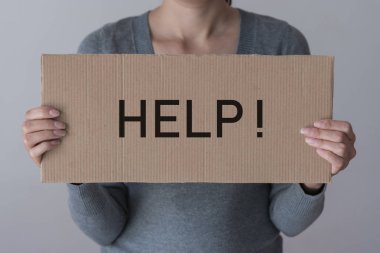 Bir kadın yardım yazıt ile bir afiş tutar