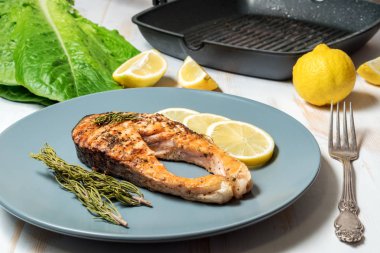 Somon fileto. Ot ve plaka üzerinde limon ile ızgara somon. 