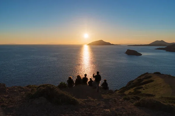 Sziluettjét az emberek a tenger sunset vigyáznak — Stock Fotó