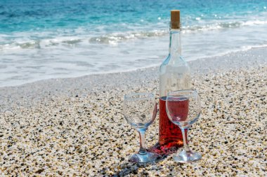 Yaz güneşli gün plajda şarap bardakları ile kırmızı şarap şişe