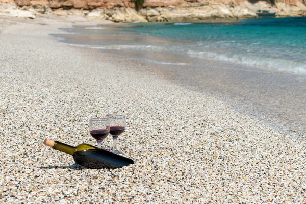 Copas de vino tinto y botella en la playa en el día soleado de verano —  Fotos de Stock