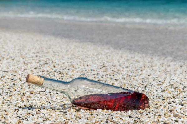 Flaska rött vin på stranden, på den soliga sommardag. — Stockfoto