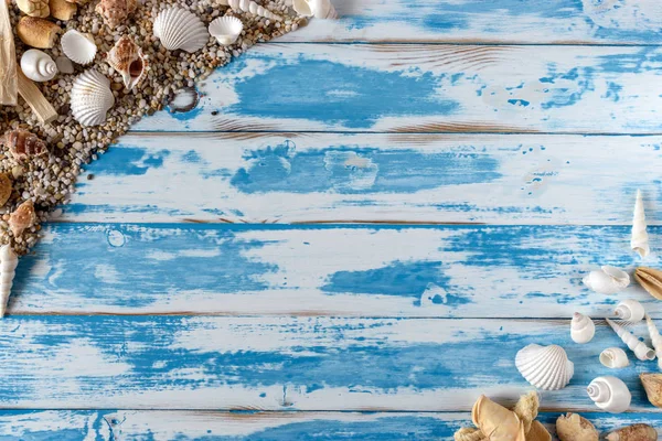 Struttura in conchiglie di mare su tavola di legno blu vintage. Estate sfondo vacanza . — Foto Stock