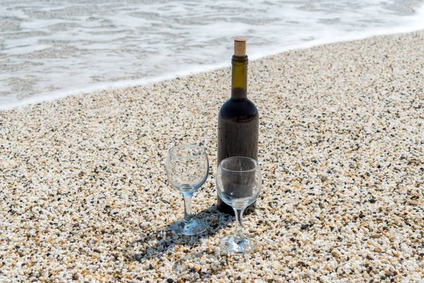 Fles rode wijn met wijnglazen op het strand bij de zomerdag — Stockfoto
