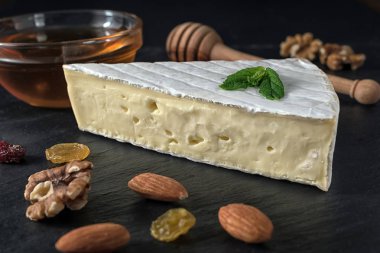 Taze Brie peyniri fındık, bal ve otlar ile kara taş tahta üzerinde