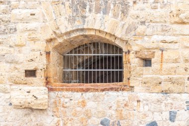 Taş duvarda demir ızgara olan pencere..