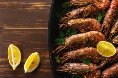 Kızarmış karides ve taze otlar ve limon dilimi. Deniz ürünleri arka planı.