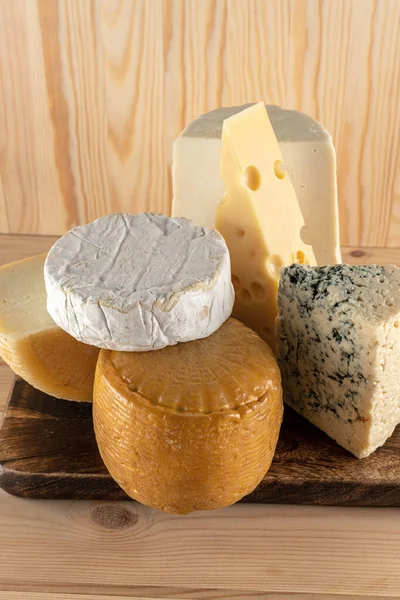 Assortment of different cheese types on wooden table. Cheese background. Top view.