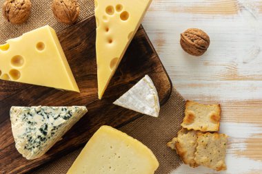 Beyaz ahşap masada değişik peynir çeşitleri var. Peynir arkaplanı.