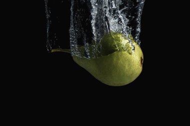 Siyah arka planda izole edilmiş taze yeşil armut. En az gıda konsepti.