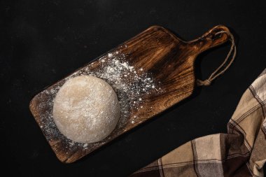 Ekmek için taze çiğ hamur ya da un tozlu, ahşap bir arka planda pizza. Üst görünüm.