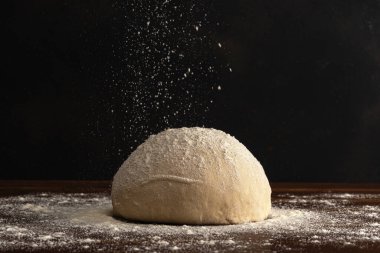 Pasta şefi, ekmek için taze hamur üzerine un serper ya da arka planda pizza..