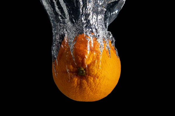 黒の背景に隔離された水のスプラッシュで新鮮なオレンジ色の果物 最小限の食品コンセプト — ストック写真
