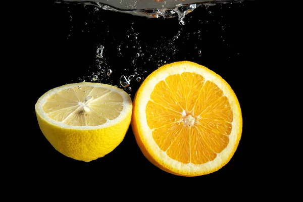 Naranja Fresca Rodajas Limón Salpicaduras Agua Aisladas Sobre Fondo Negro — Foto de Stock