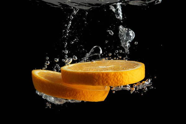 Fruta Naranja Fresca Rodajas Salpicadura Agua Aislada Sobre Fondo Negro — Foto de Stock