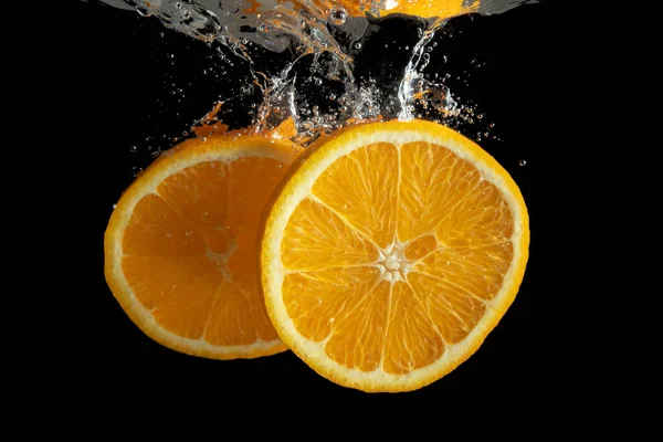 Свежие Нарезанные Апельсиновые Фрукты Воде Брызги Изолированы Черном Фоне Минимальная — стоковое фото