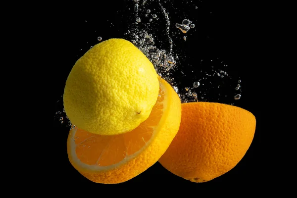 Naranja Fresca Rodajas Limón Salpicaduras Agua Aisladas Sobre Fondo Negro — Foto de Stock