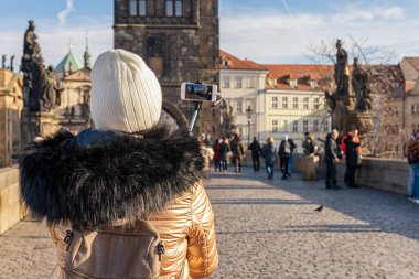 Kız gezgin Prag 'da Charles Bridge' in fotoğraflarını çekiyor. Çek Cumhuriyeti.