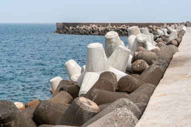 Dalgakıran koruması mavi gökyüzü altında, Heraklion limanında katı beton bloklar. Yunanistan.